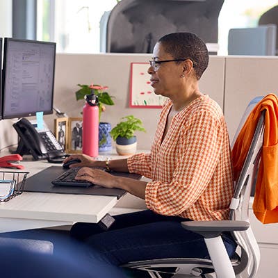 A Field Reimbursement Manager sitting in front of her computer, smiling