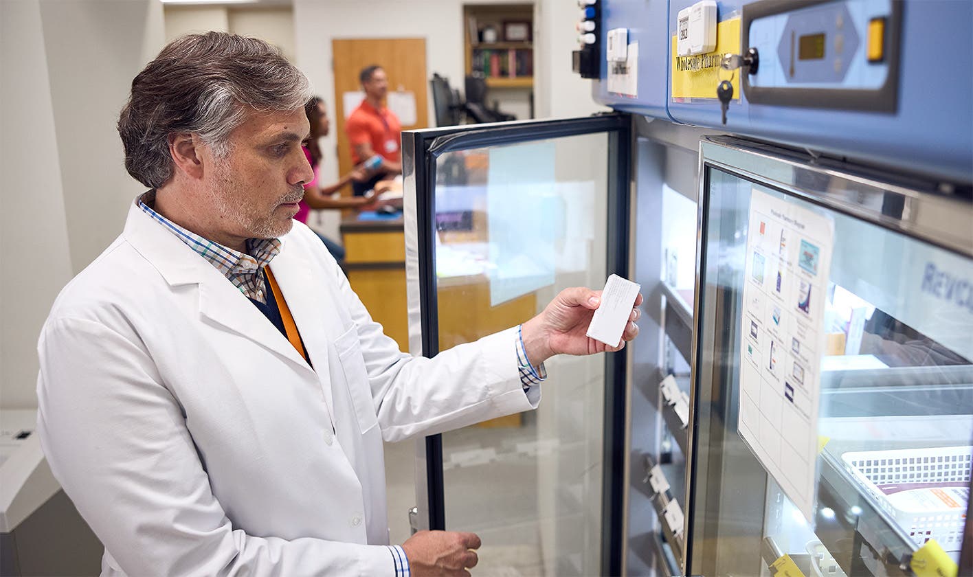 Pharmacist accesses specialty biologics medication from cold storage