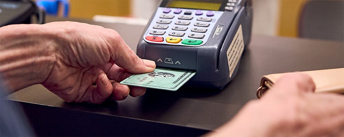 Patient using credit card to pay for medications at the pharmacy counter.