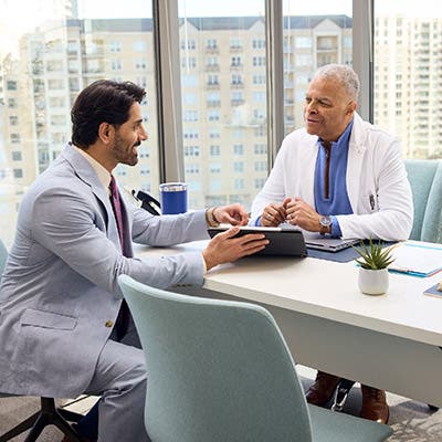 A FRM consulting a provider on a tablet in the provider's office