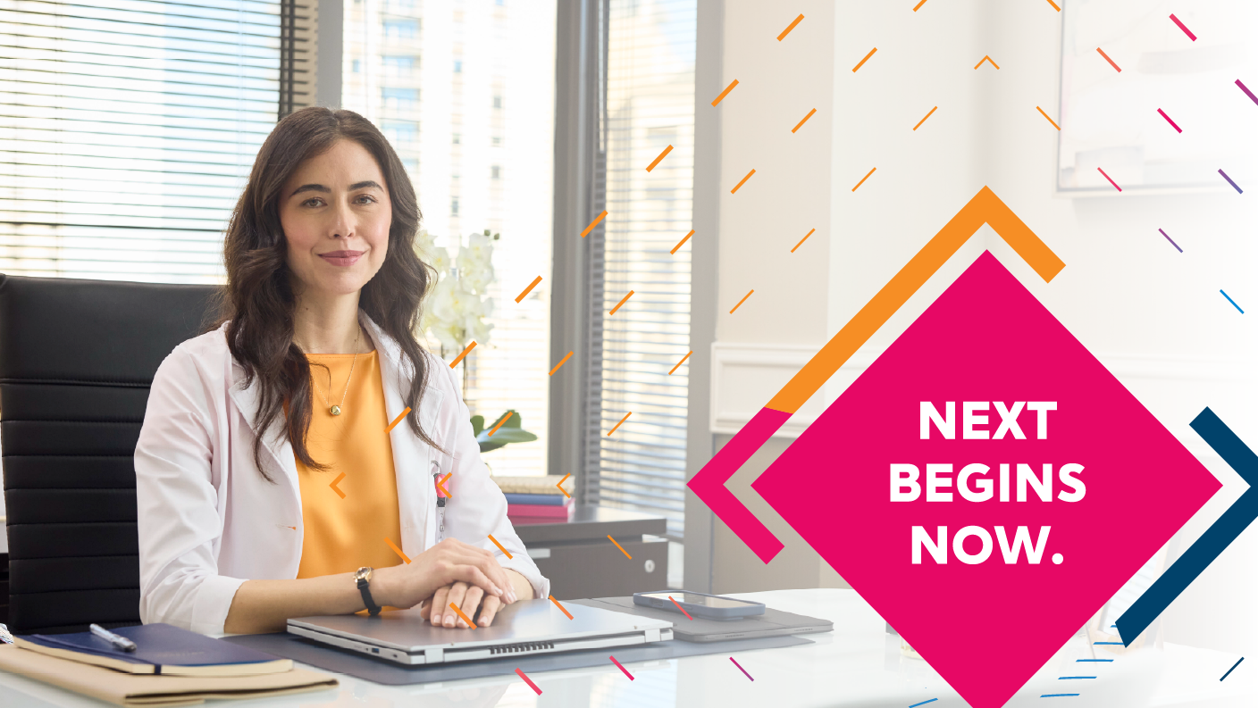 A healthcare professional sitting in an office setting at a desk. At CoverMyMeds, next begins now.