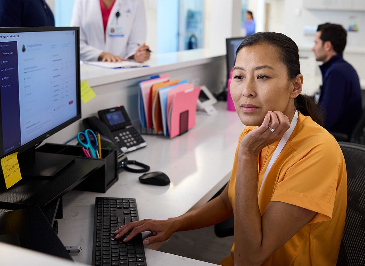 Care team member sitting at the computer in a provider's office processing prior authorizations
