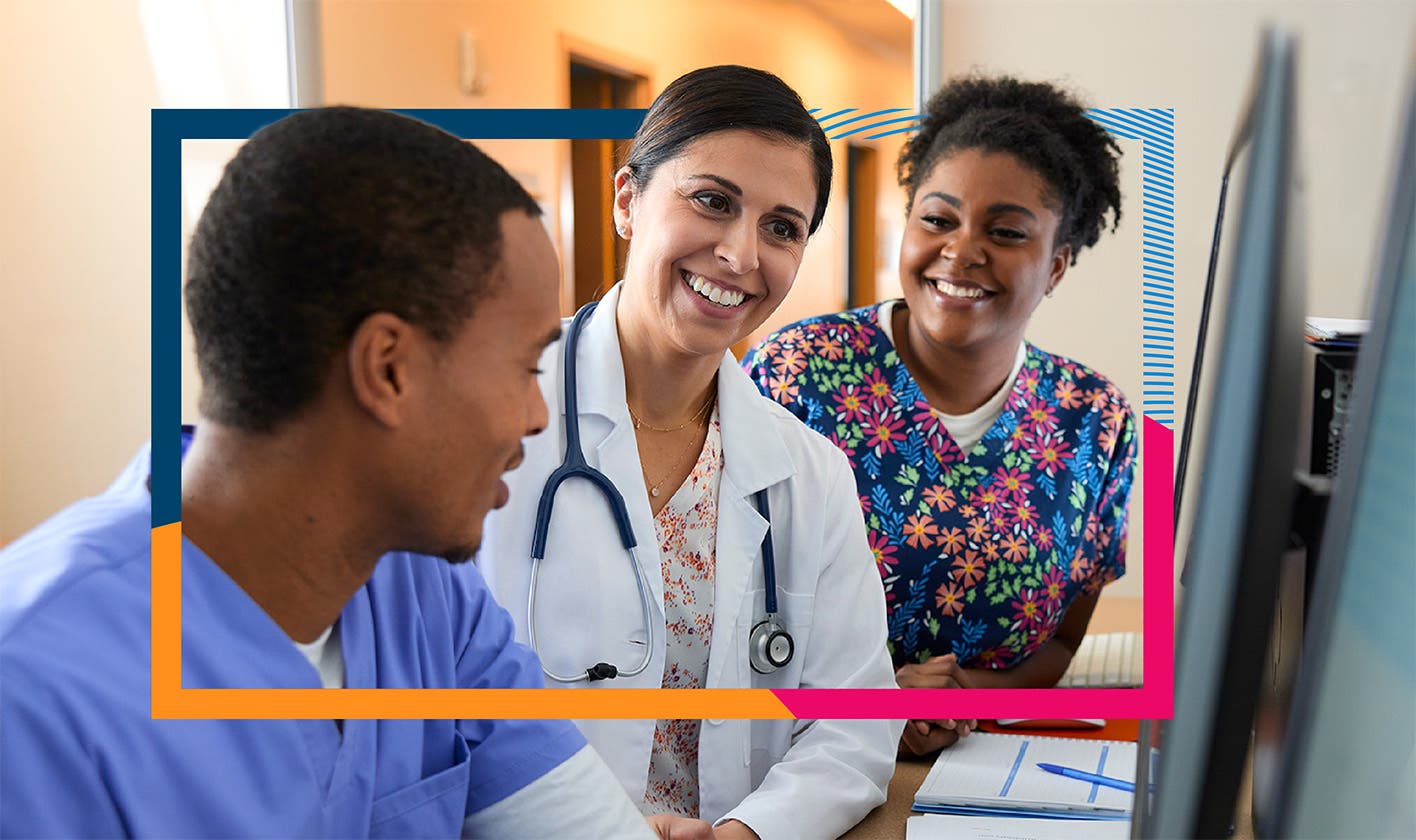 A provider and two care team members share a happy moment while reviewing a computer monitor together in a medical clinic.
