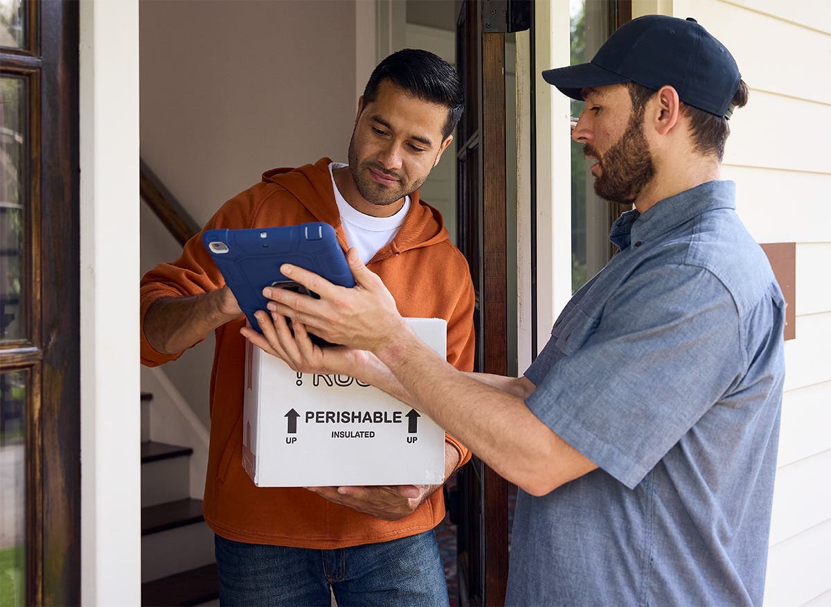 Patient signs a tablet to confirm receipt of a home-delivered medication from a courier