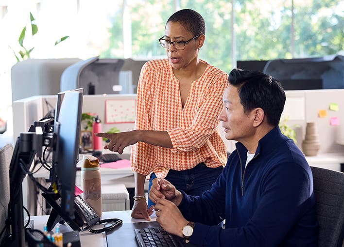 Two corporate colleagues consulting with one another at a computer