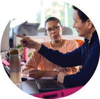 A provider sitting next to a patient pointing at a computer
