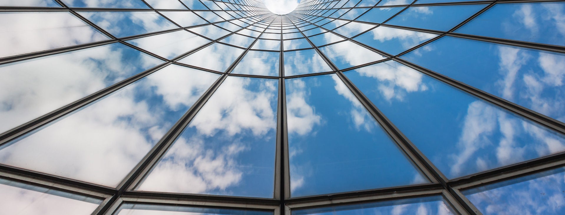 blue sky and white clouds reflected in glass building